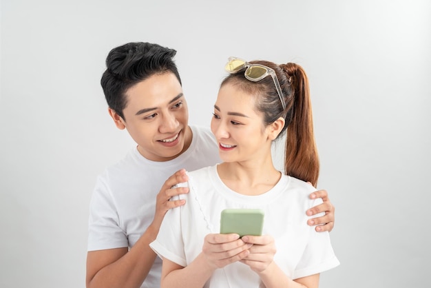 Curious boyfriend is spying his lovers smartphone, standing isolated on white background