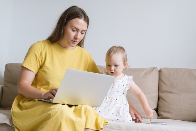 Curious child looking at mother laptop display mother using gadgets for baby entertainment