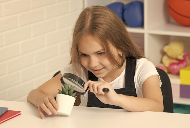 Curious child looking at plant through magnifying glass curiosity