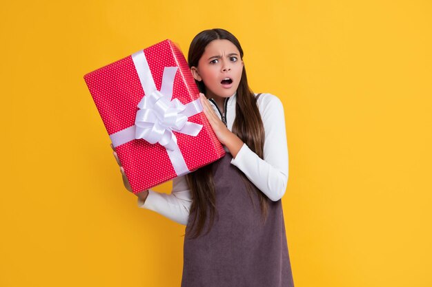 Curious child with present box on yellow background