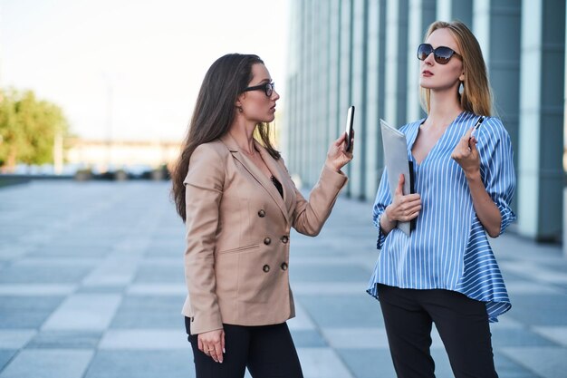 Curious journalist is taking photo of sucessful businesswoman on the street.