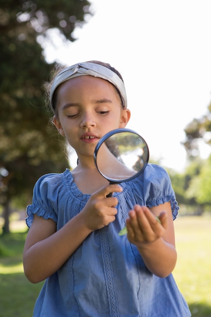 Curious little girl looking at leaf