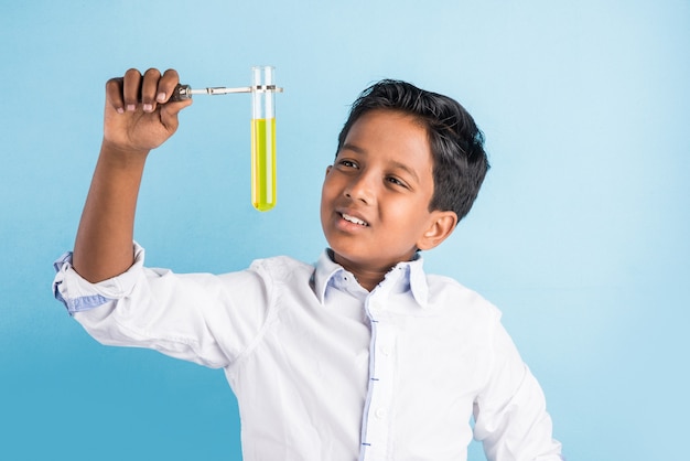 Curious little Indian school kids or scientists studying science, experimenting with chemicals or microscope at laboratory, selective focus