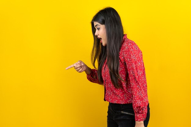 Curious pretty woman with glad expression isolated on yellow background