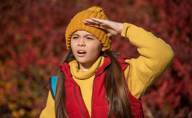 秋のシーズンに屋外の学校の時間で好奇心旺盛な十代の少女