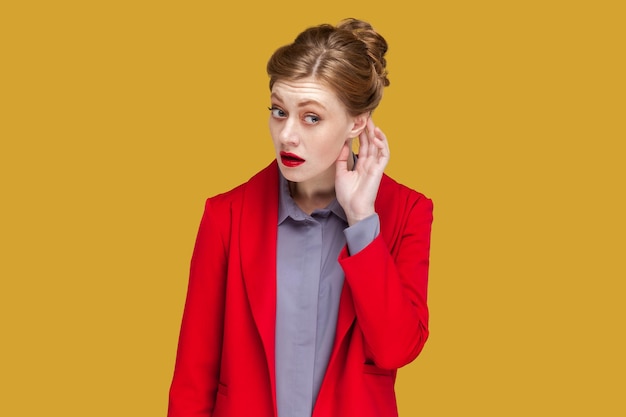 Curious woman with red lips with hand near ear listening something interesting private conversation