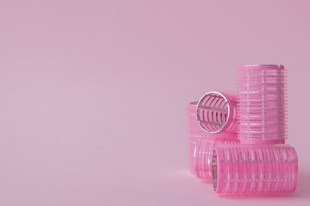 Curlers hair plastic on a pink space with copy space