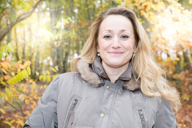 Curly blonde woman in autumn park happy smile beauty