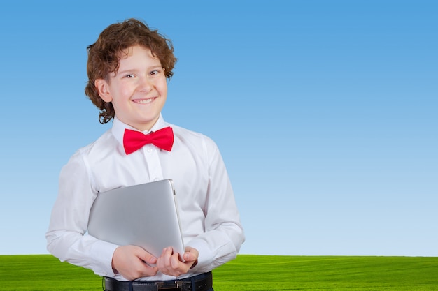 Curly boy in formal suit with laptop