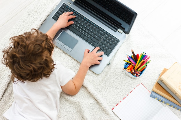 Curly Boy kijken Monitor bovenaanzicht. Concept van training, afstandsonderwijs tijdens quarantaine COVID 19