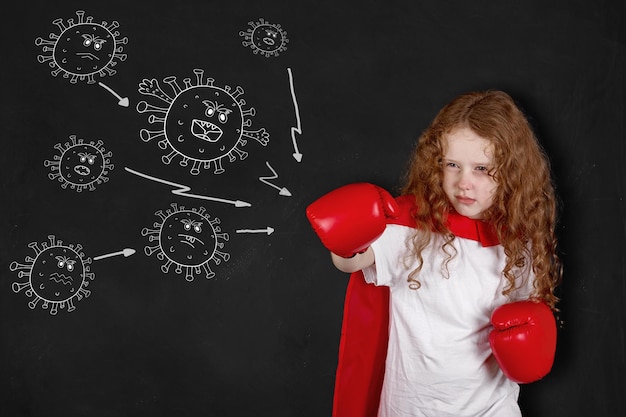 Curly girl in red boxing gloves is protecting herself from the coronavirus. Health concept.