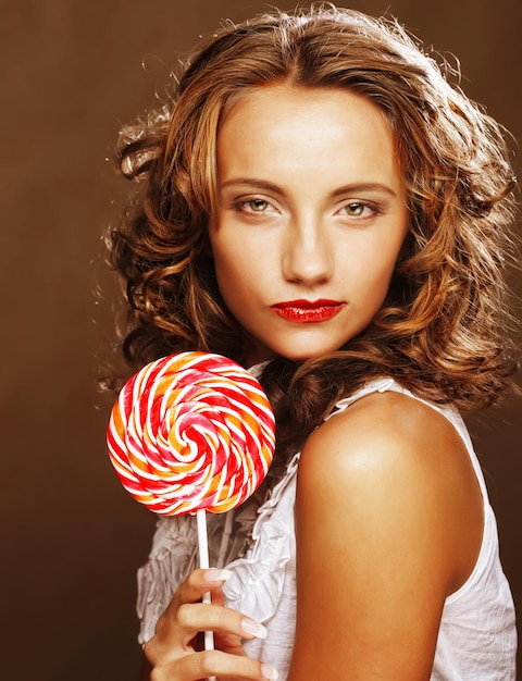 Curly girl with a lollipop in her hand