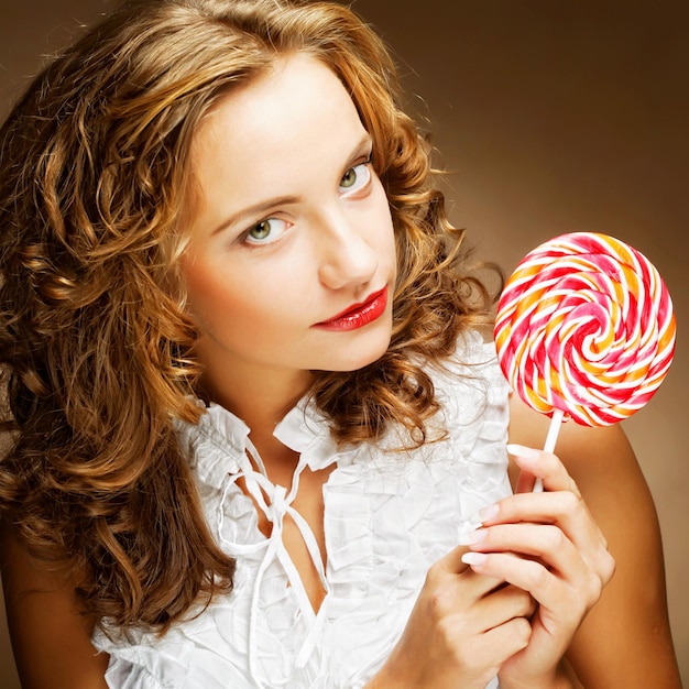 Curly girl with a lollipop in her hand