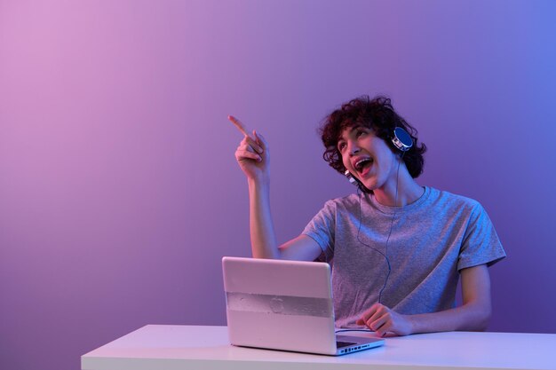 Curly guy sitting at the table gaming laptop lifestyle
technology