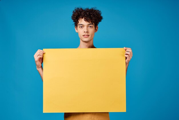 Curly guy with yellow mockup poster blue background High quality photo