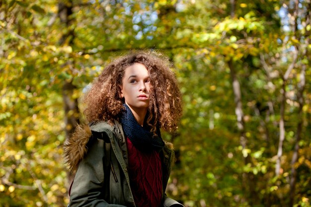 Curly hair teen girl in autumn forest