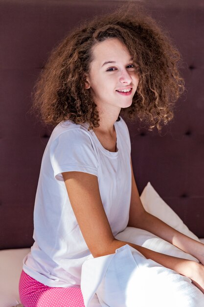 Photo curly hair teen girl on the bed