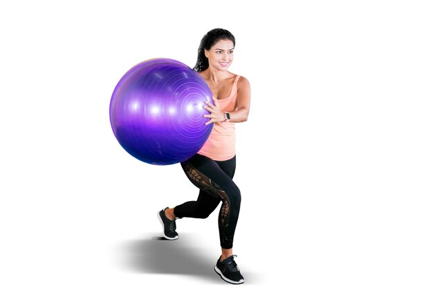 Вьющиеся волосы женщины упражнения с мячом для йоги на студии