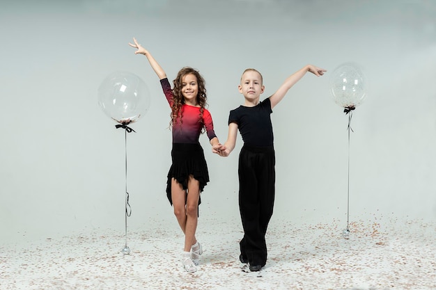 Foto una ragazza dai capelli ricci e un ragazzo impegnati in una posa di danza da sala da ballo che mostra elementi di danza