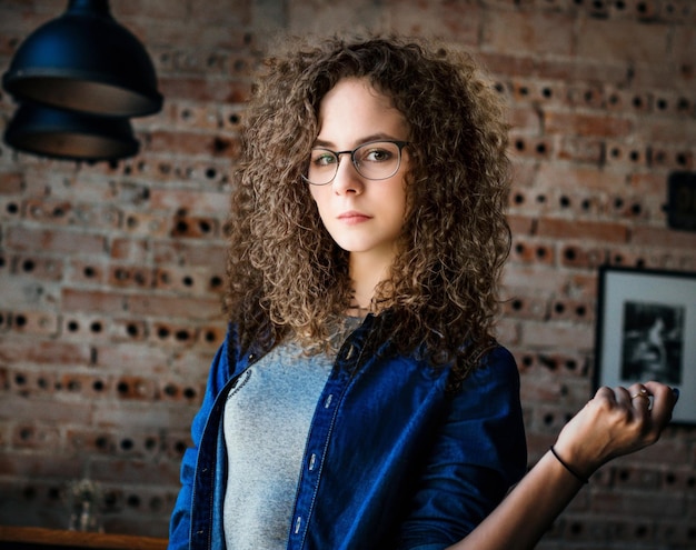 Photo curly-haired girl with glasses poses