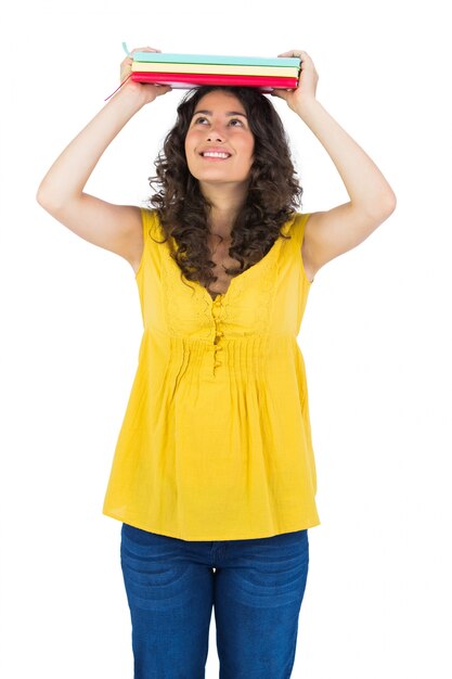 Photo curly haired student holding notebooks on her head