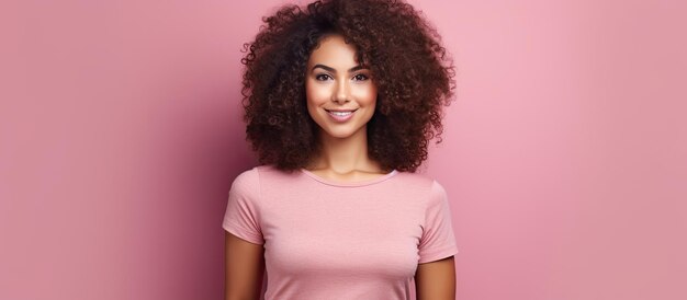 Curly haired woman blogger poses with phone on pink background technology and social media