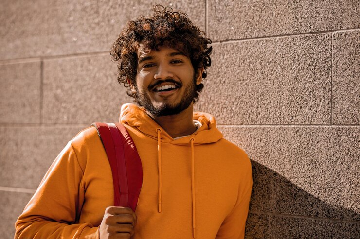 Curly-haired young man with a backpack in the street