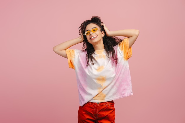 Curly happy young girl teenager wearing sunglasses looking away rejoicing