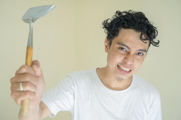 Curly man hold spatula and cap pan with fight expression