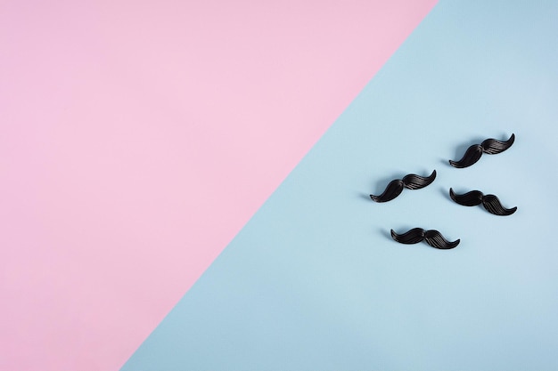 Curly mustaches on colorful background Fake mustache Top view