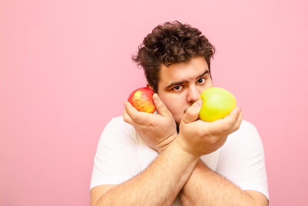 Curly overweight guy eating apples on a diet