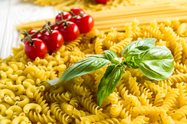 curly pasta and basil leaf on the table