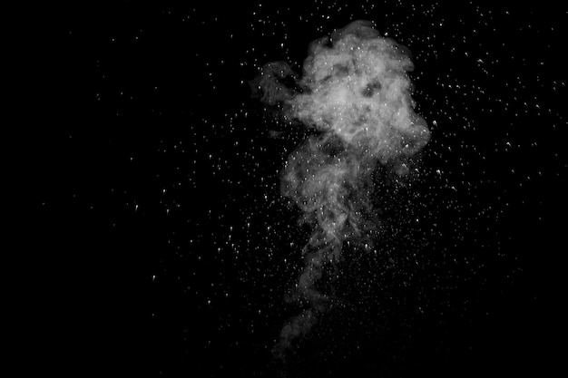 Curly white steam rising up and splashing water scattering in different directions isolated on a black background Evaporation of liquid and condensation Can be used as background design element