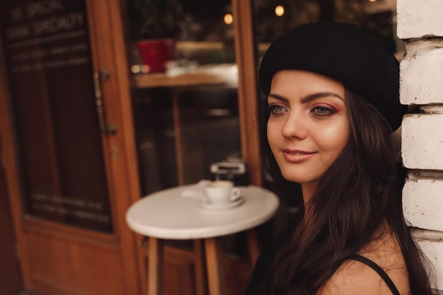 Curly woman in retro hat in cafe