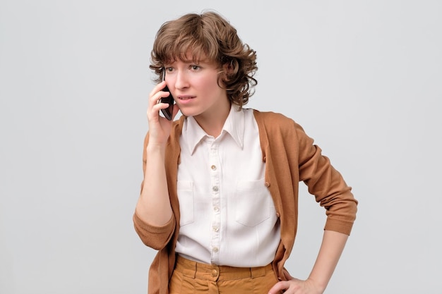 Curly woman talking on phone looking aside