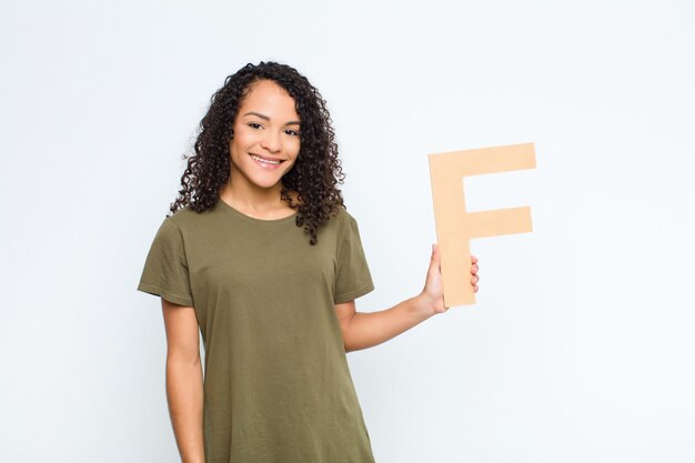 curly young woman holding the letter f