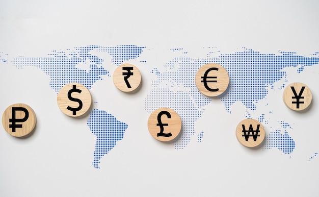 写真 通貨記号には、ドル元円ユーロ ルーブル ルピーとポンド スターリング プリント スクリーンが木製に含まれており、両替送金と外国為替取引の概念のためのドット世界地図が表示されます