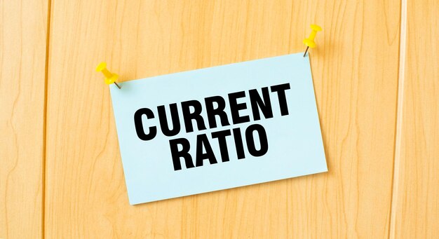 CURRENT RATIO sign written on sticky note pinned on wooden wall