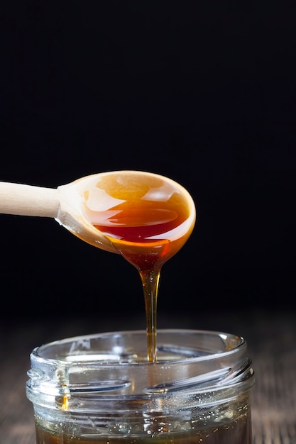 現在の濃厚でおいしい甘い蜂蜜、ミツバチによって作られた自然で健康的な食品、天然ミツバチは粘り気があり濃厚な粘り気があります