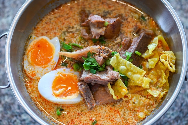 Curry bone soup bone soup pork with boiled eggs in hot pot Thai food tom yum hot and sour soup