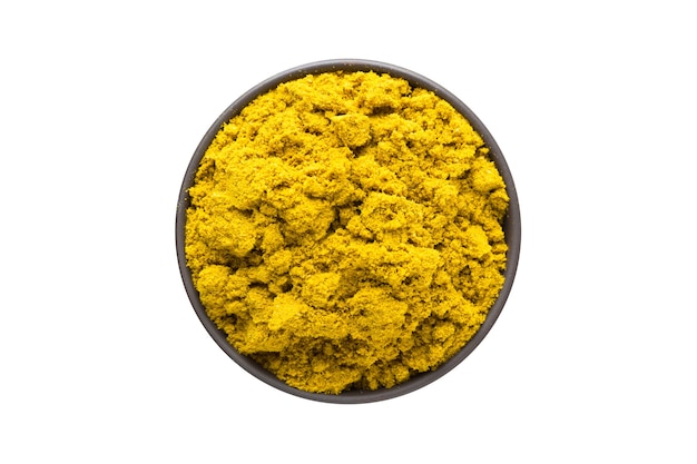 Curry powder in clay bowl isolated on white background