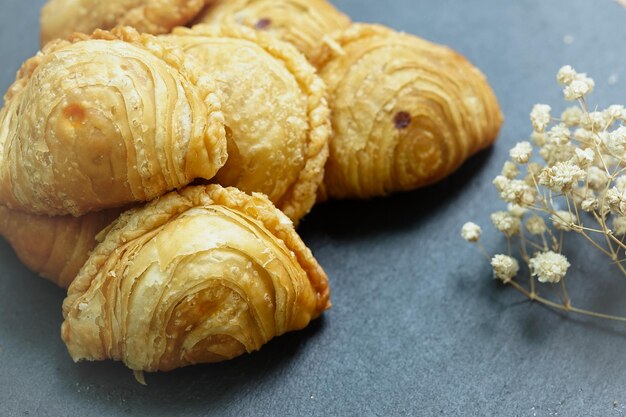 Curry puff pastry in a stone plate placed on a wooden table