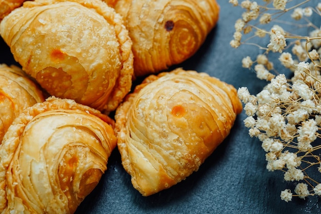 Curry puff pastry in a stone plate placed on a wooden table