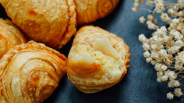 Curry puff pastry in a stone plate placed on a wooden table