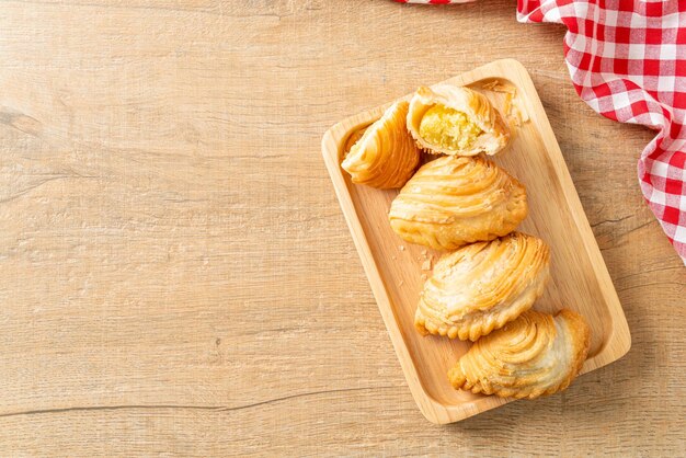 Photo curry puff pastry stuffed beans on wooden plate