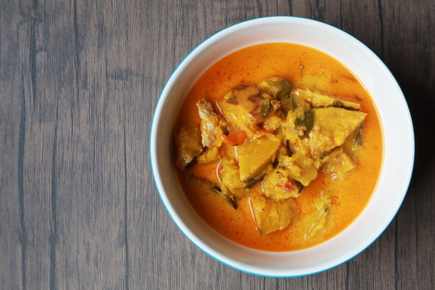 Curry pumpkin in the white bowl on wooden table