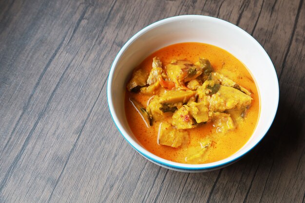 Curry pumpkin in the white bowl on wooden table