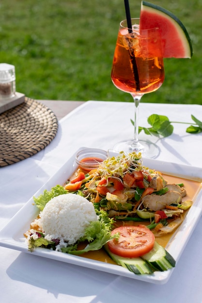 Curry with chicken seafood and vegetables on a white plate