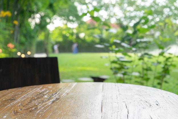 야외의 흐릿한 정원 배경 앞에 의자가 있는 곡선 원 빈티지 오래되고 고전적인 나무 테이블