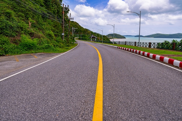 タイのプーケット島の熱帯海近くのカーブした道路。